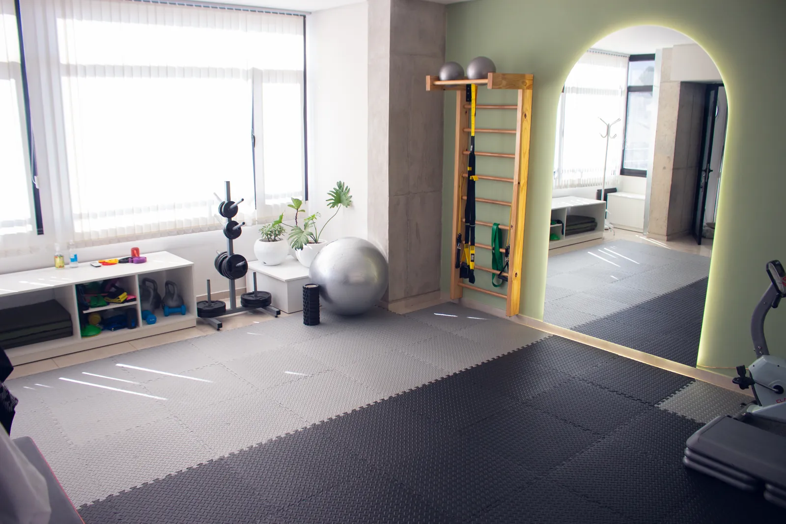 Sala de kinesiología del centro, con espaldar, pelotas, pesas y luz natural
