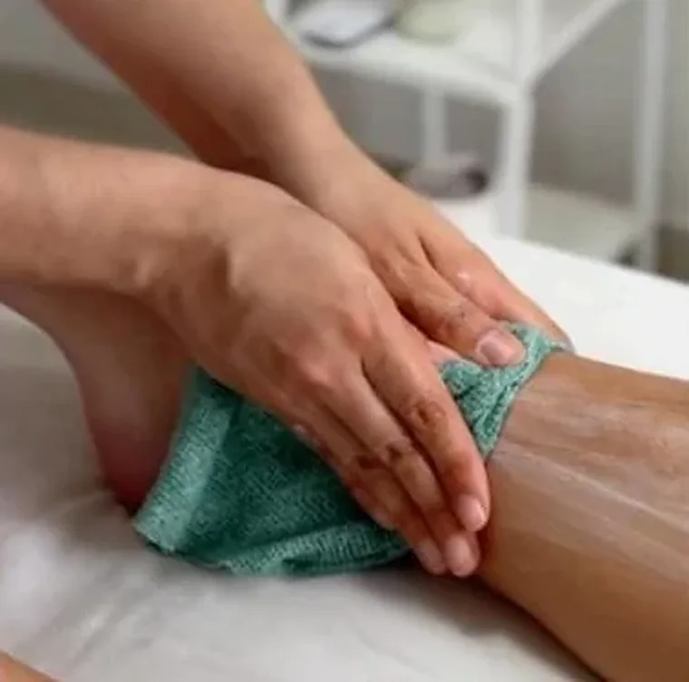 Exfoliación corporal con guante en la pierna, parte del Ritual renovador