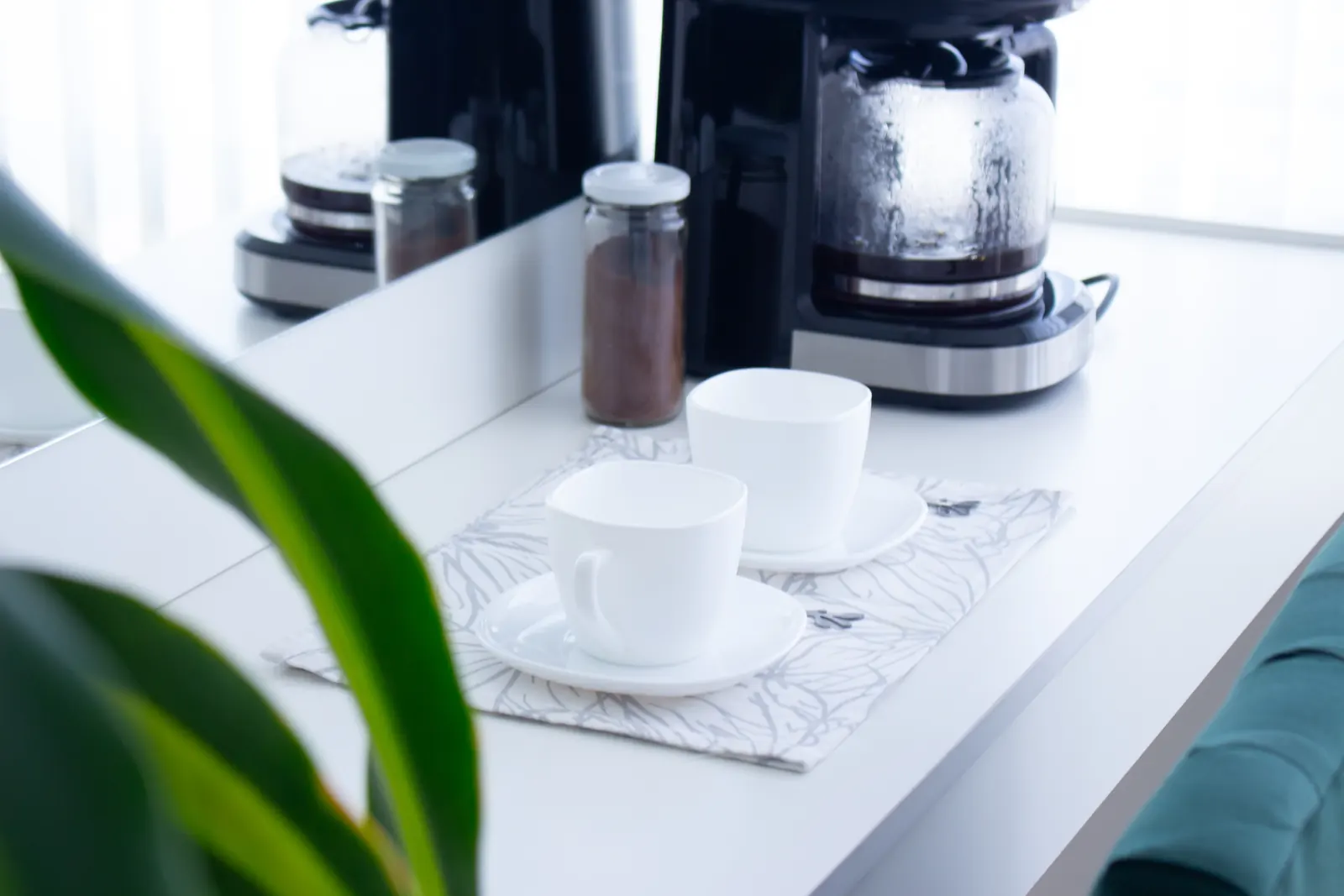 Rincón de café con tazas blancas preparadas para recibir a las clientas